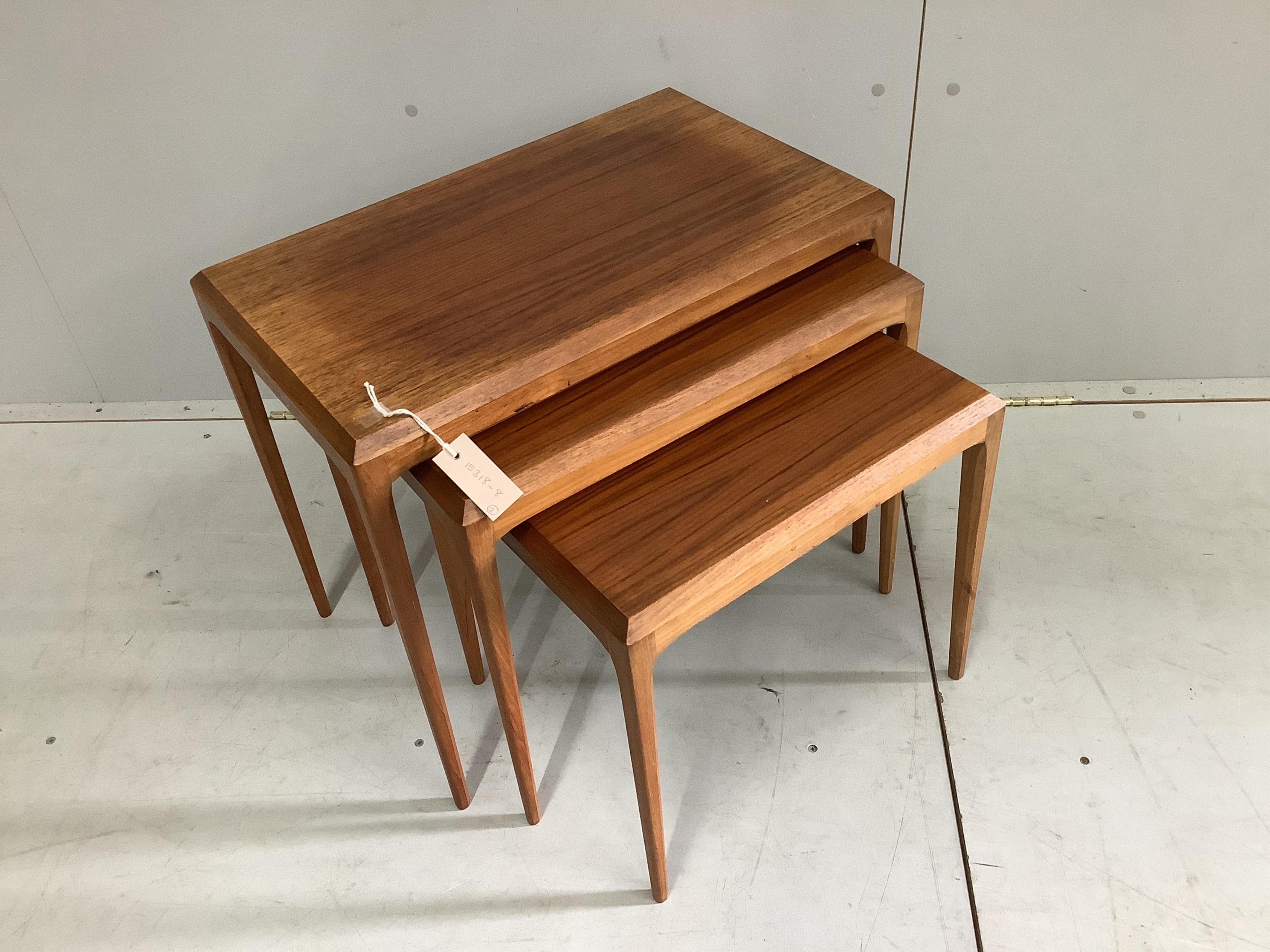 A nest of three mid-century Danish Silkeborg rectangular teak tea tables, designed by Johannes Andersen, width 59cm, depth 36cm, height 51cm. Condition - fair